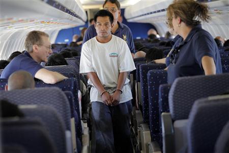 An illegal immigrant boards a plane at a flight operation unit at Mesa airport during his deportation process in Phoenix
